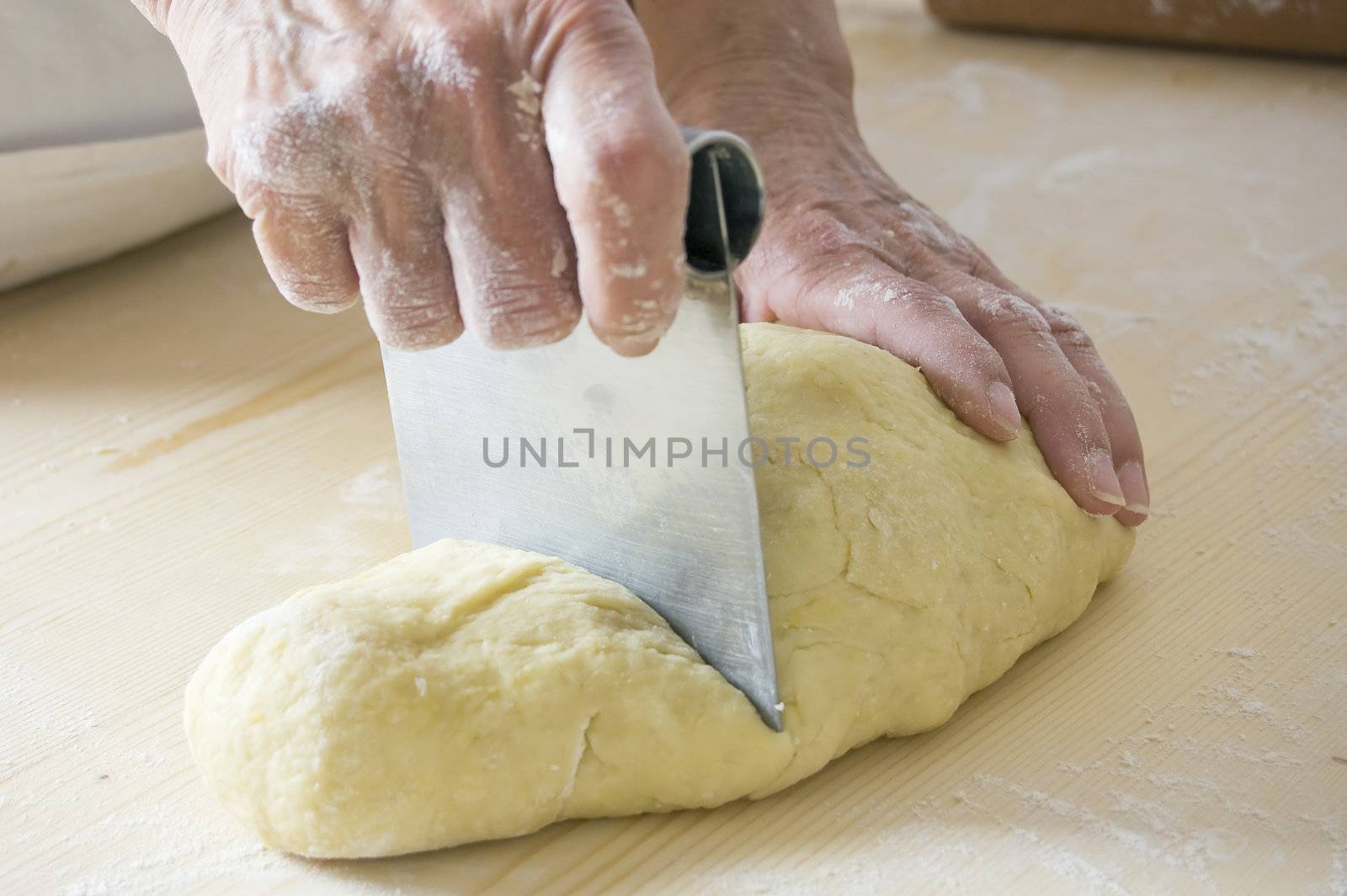Woman hands cutting dough