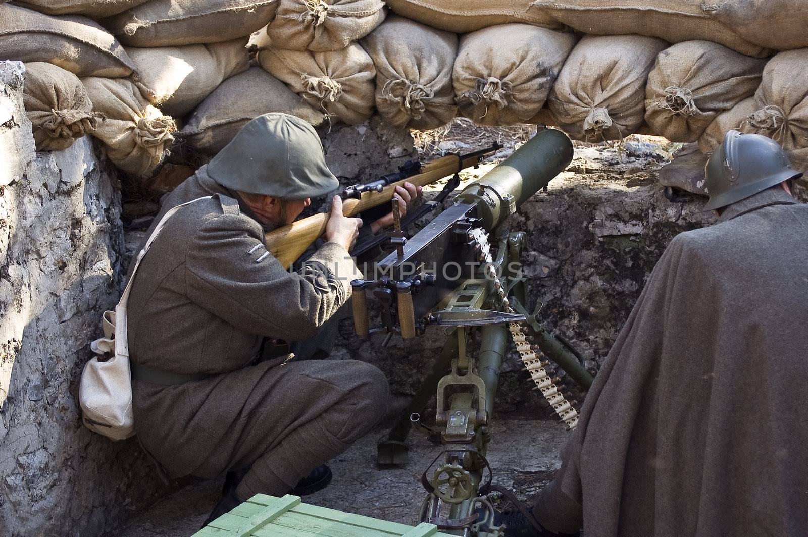 Two soldiers with machine gun in a trench