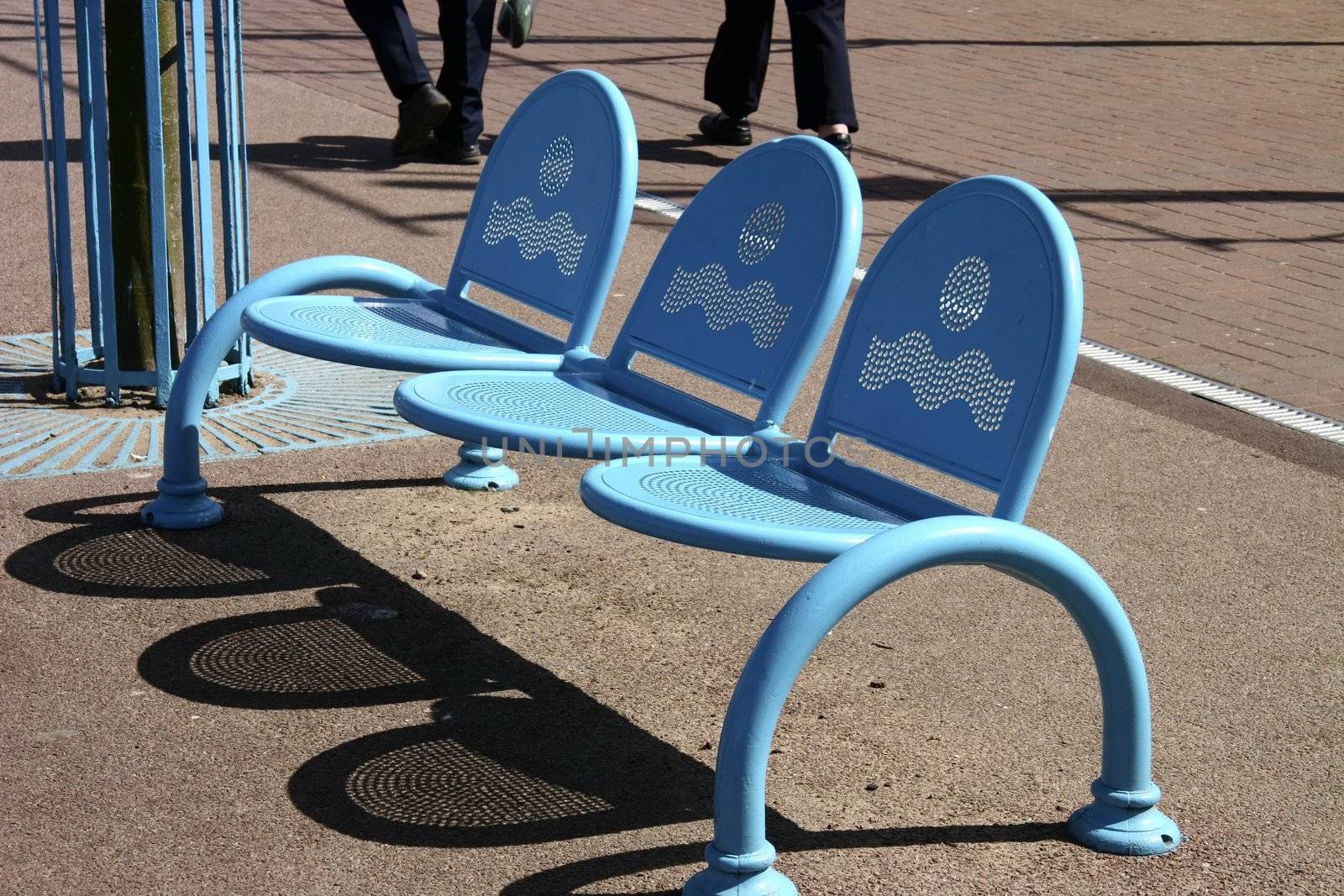 blue modern metal bench seating set in the street for the public to sit on