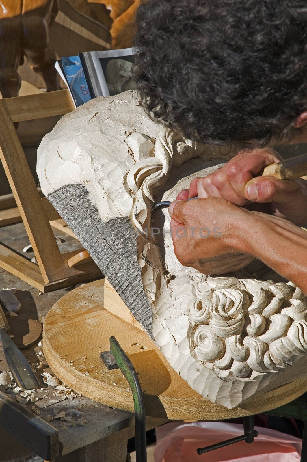 Craftsman carving a face in the wood