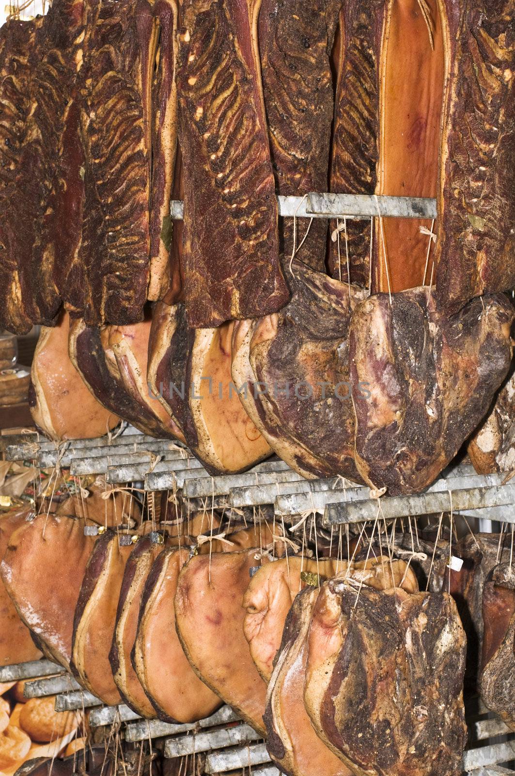 Hanged speck (salted and smocked ham) pieces drying up in a maturing storeroom.