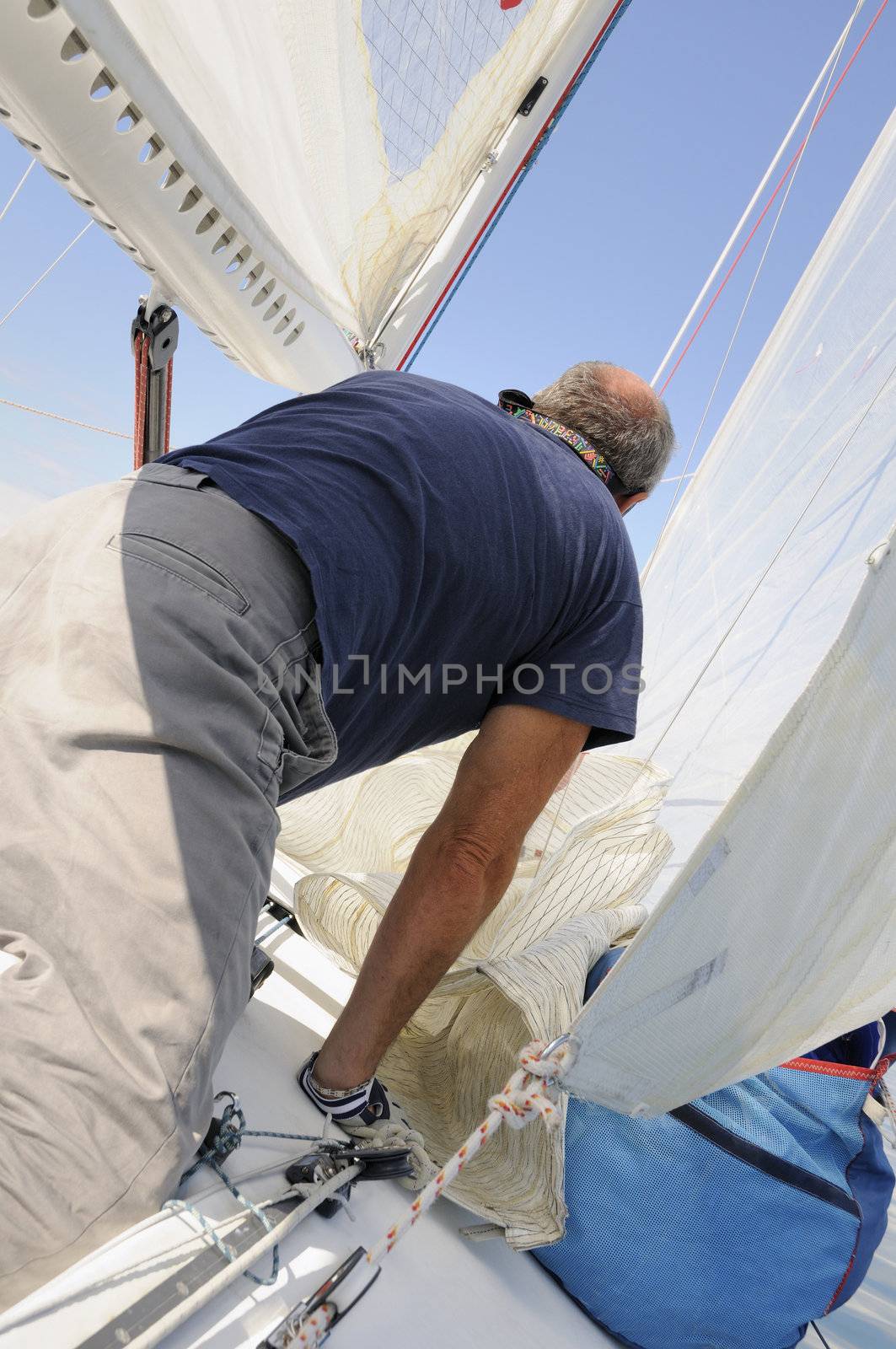 Man on a boat with sails and ropes