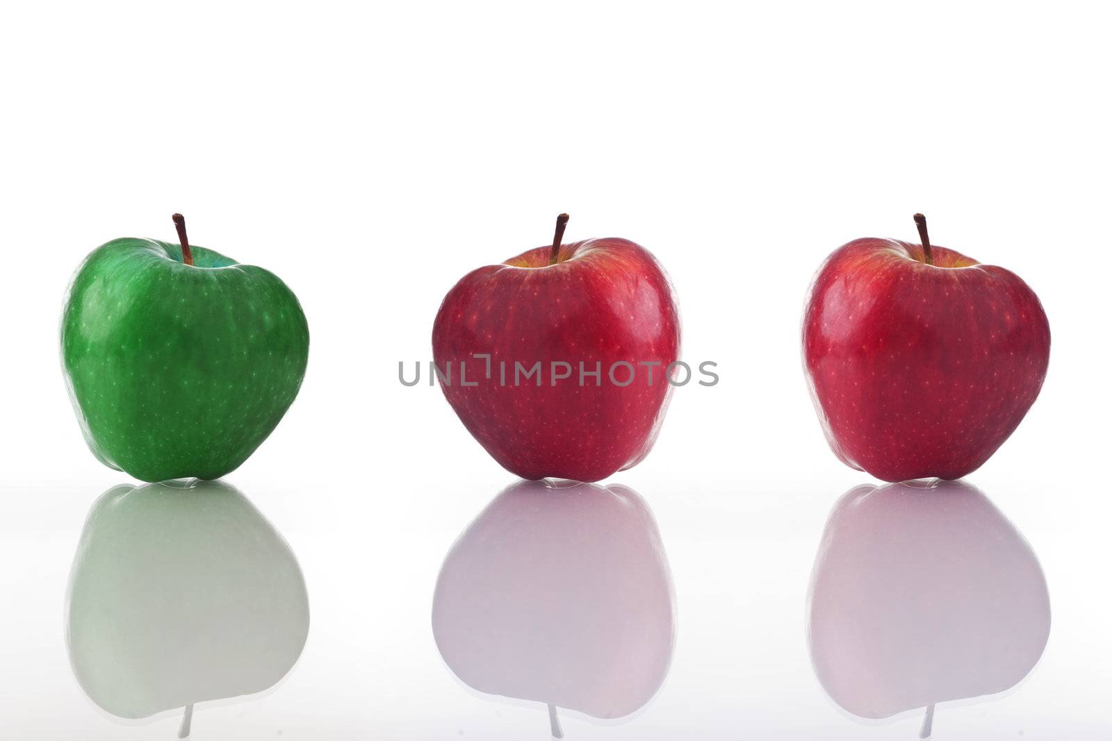 Three apples, one green and two red, isolated on white with reflection. 