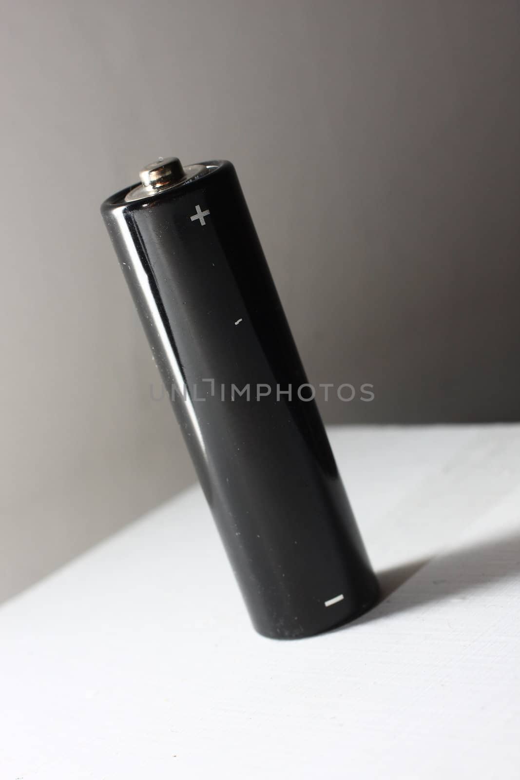 Black AA battery on white background