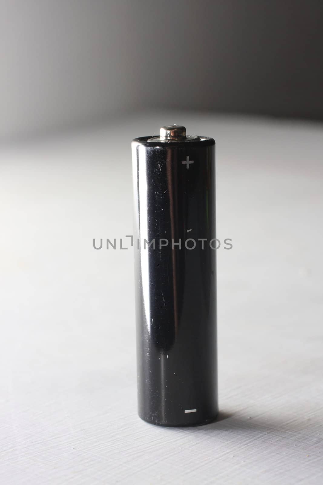 Black AA battery on white background
