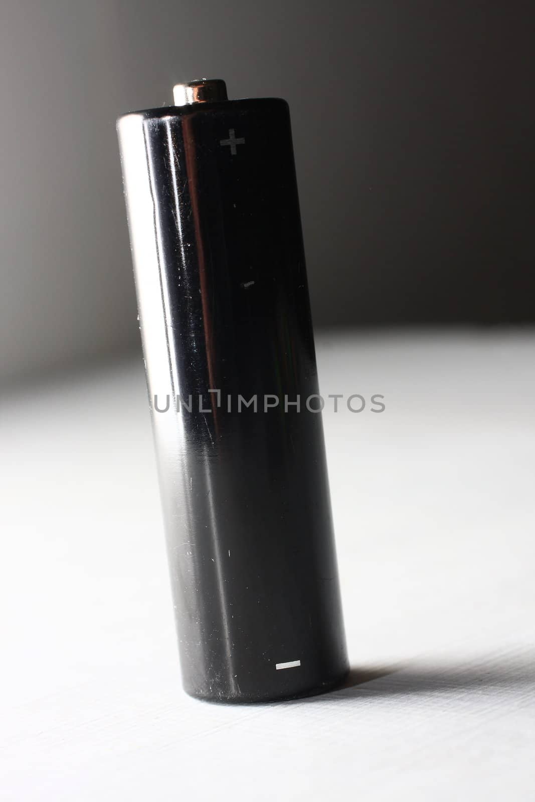 Black AA battery on white background