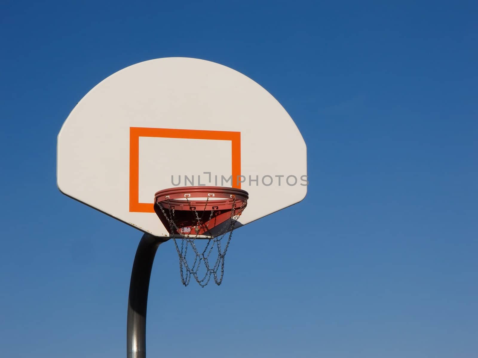 Basketball hoop with a clear blue sky background