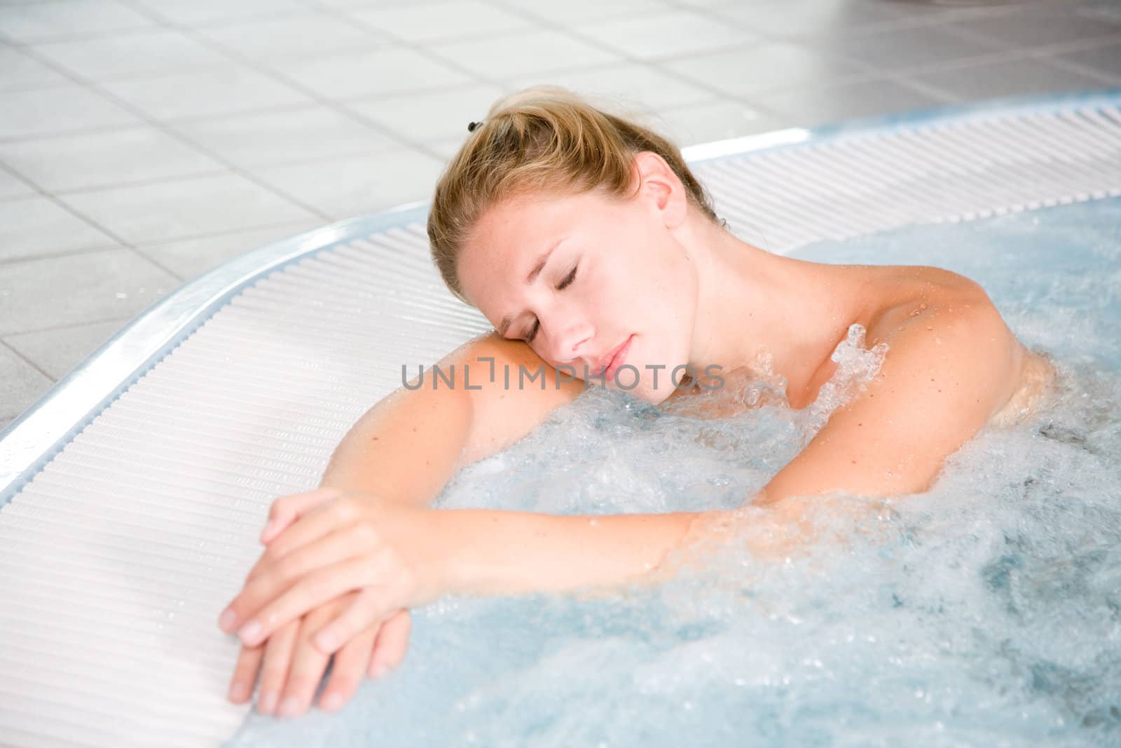 Pretty blond woman relaxing in the whirlpool