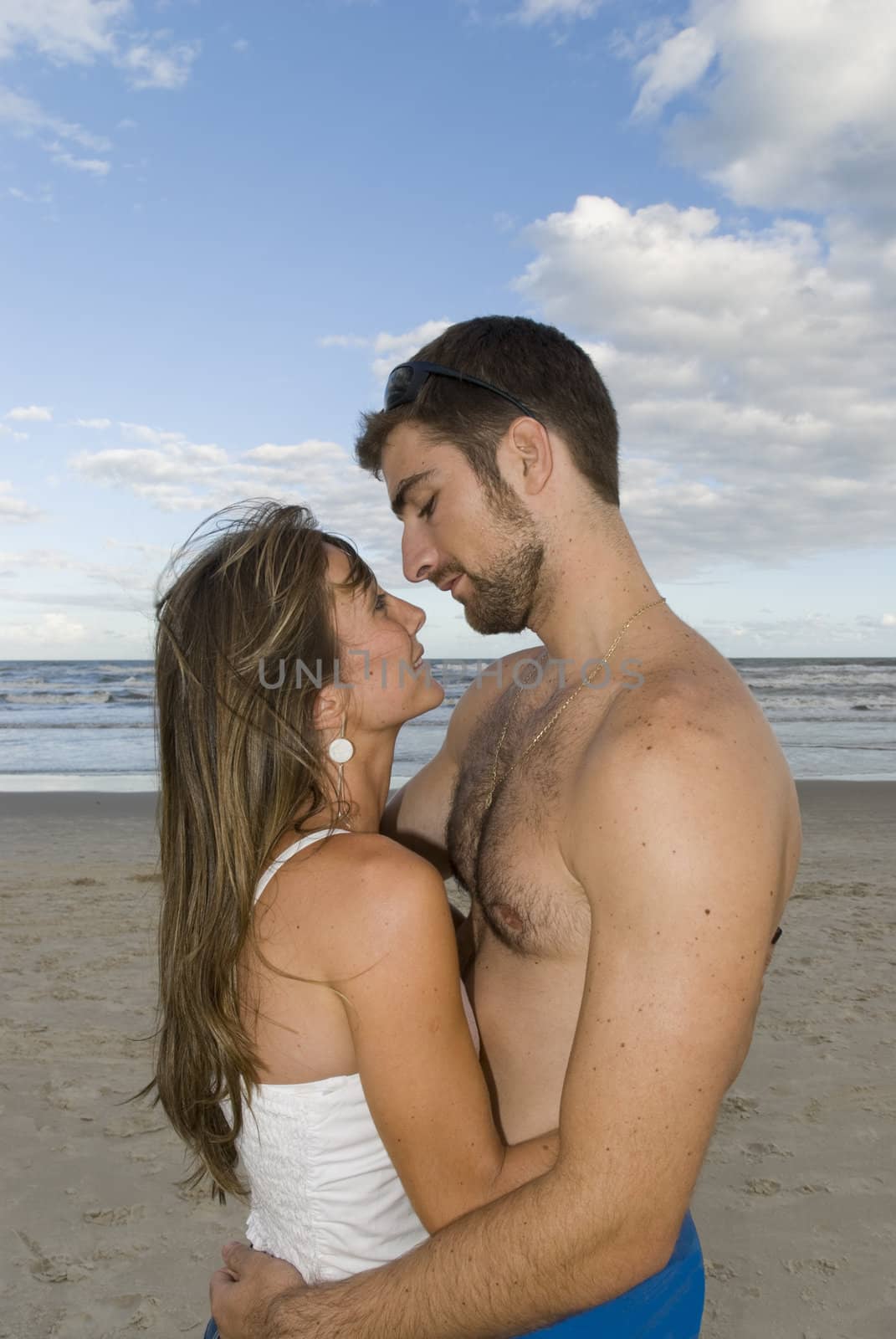 Young healthy couple kissing in the beach. 