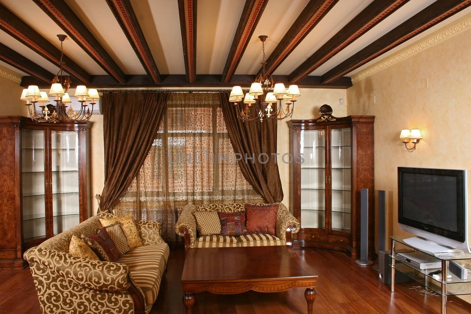 
Living room with smart furniture, a parquet floor, and a window curtained by portieres
