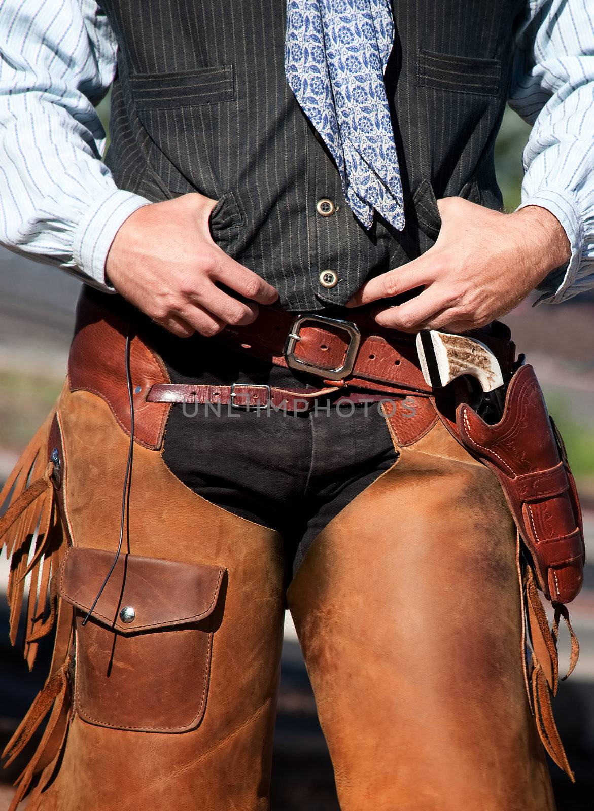 Closeup of cowboy with chaps, guns and leather belt