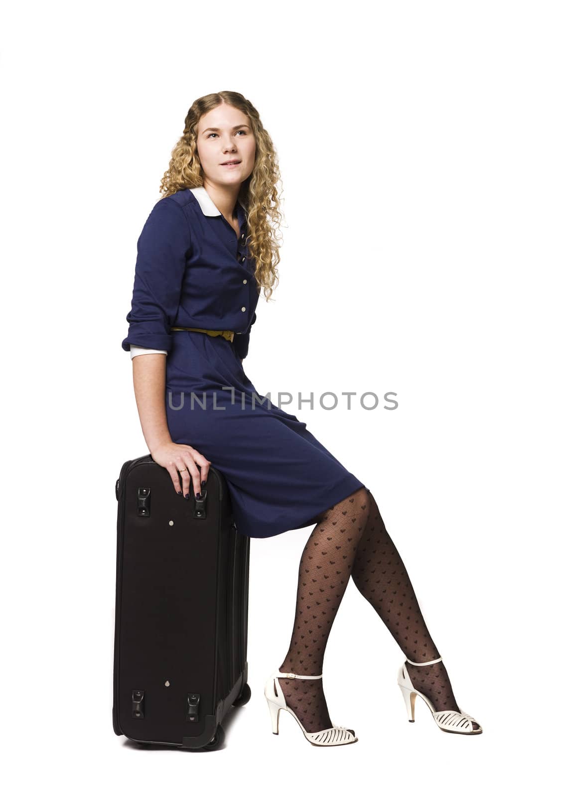 Girl siting on her suitcase waiting