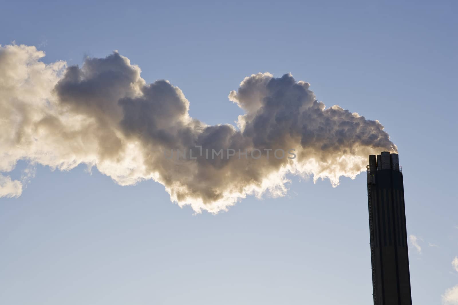 Smoking chimney against a blue sky by gemenacom
