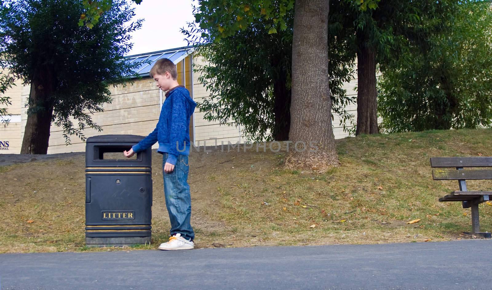 an image of a responsible teenager putting rubbish in the litter bin instead of throwing it on the floor.