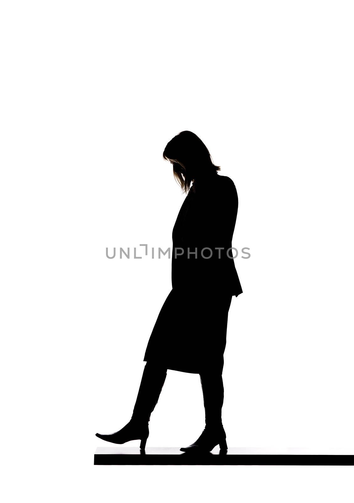 Silhouette of a woman walking on a board by gemenacom
