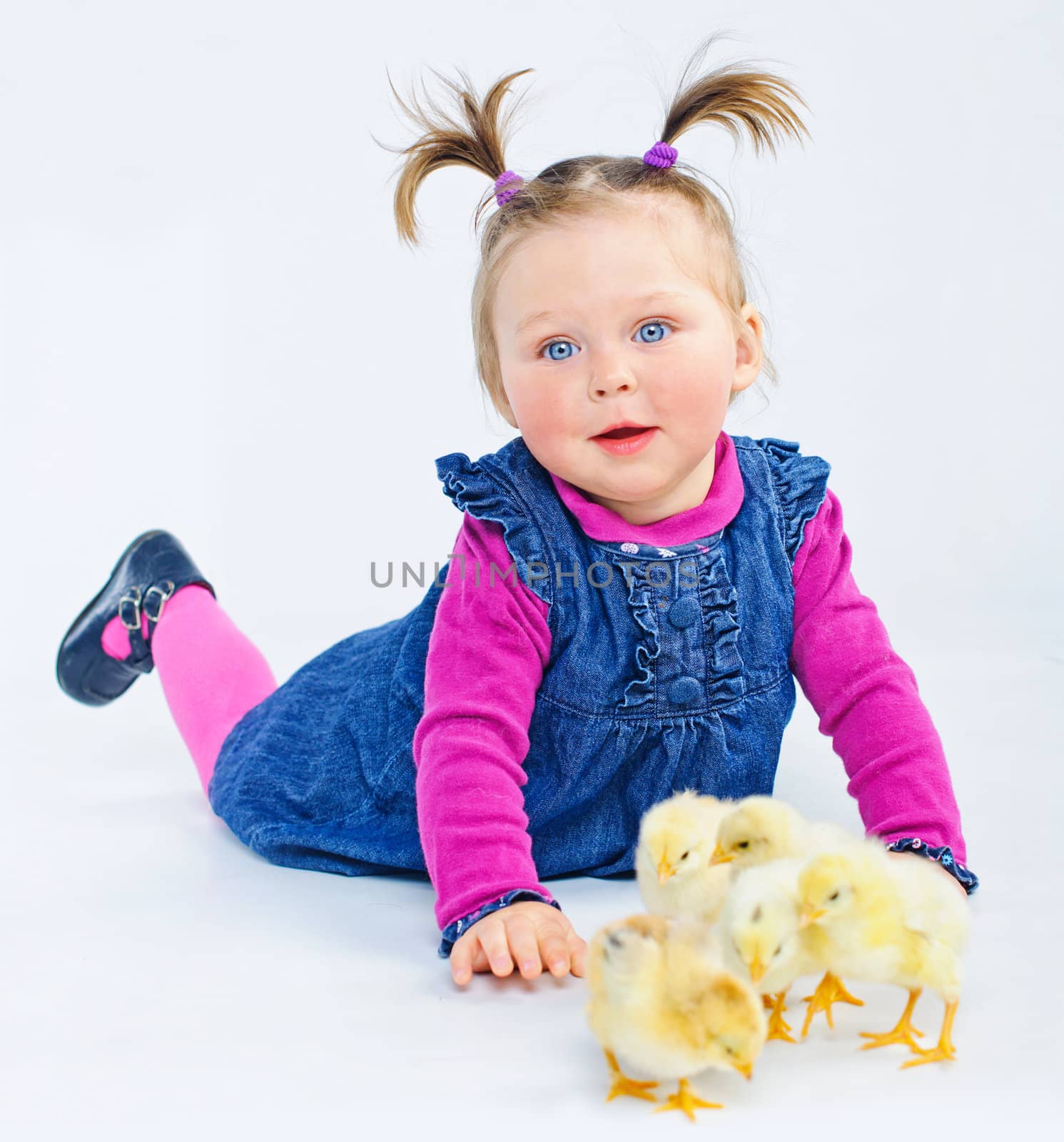 Cute little girl in rose with yellow Easter chicks