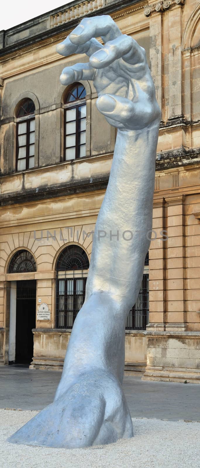 details of a sculpture involving a man half-submerged. It is located in the main square