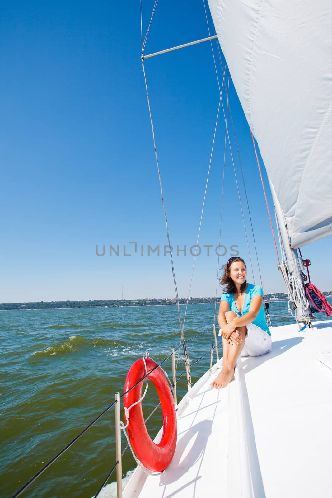 Young beautiful girl sitting on a yacht