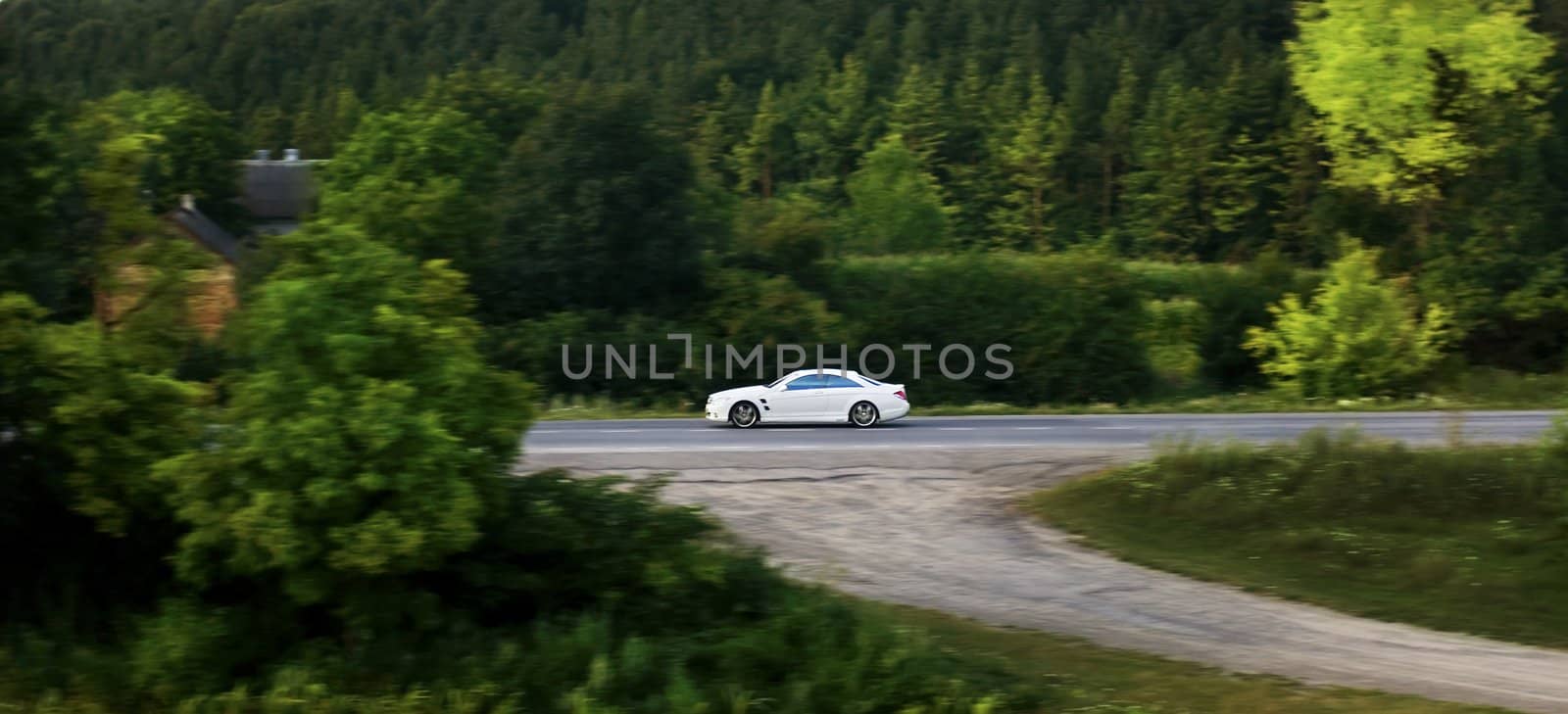 White car driving on road at summer time