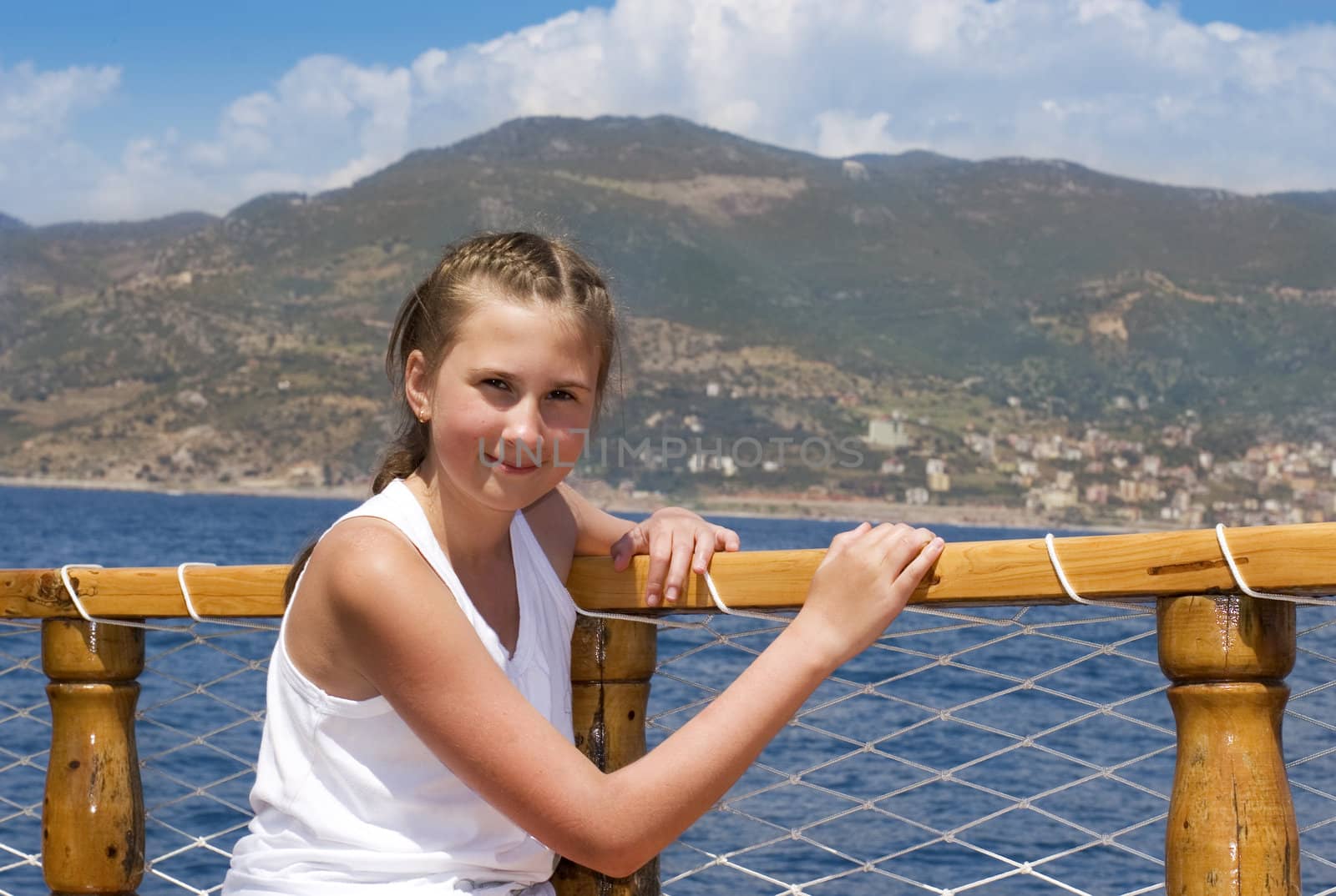 Happy young girl sitting on yacht