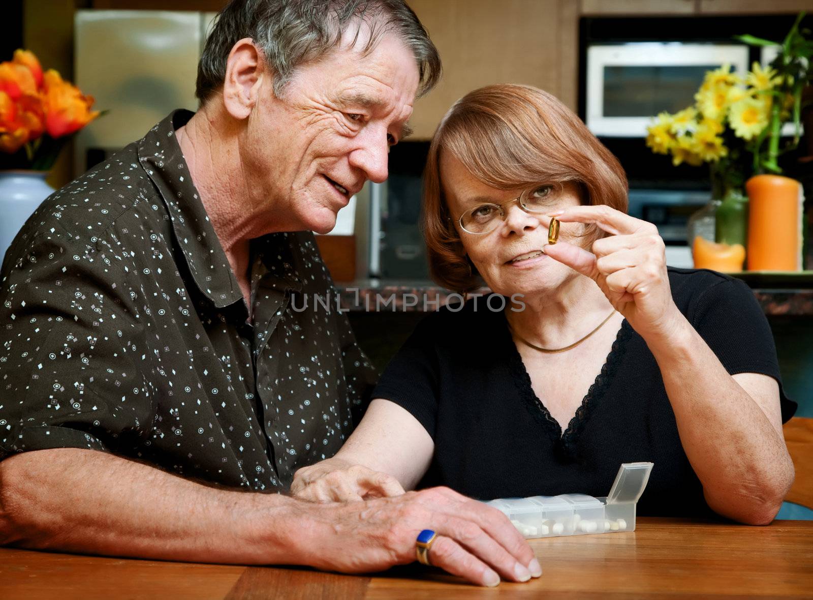 Senior couple at table with daily health supplements