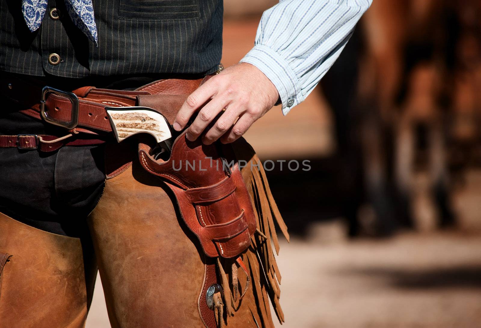 Closeup of cowboy with chaps, gun and leather belt