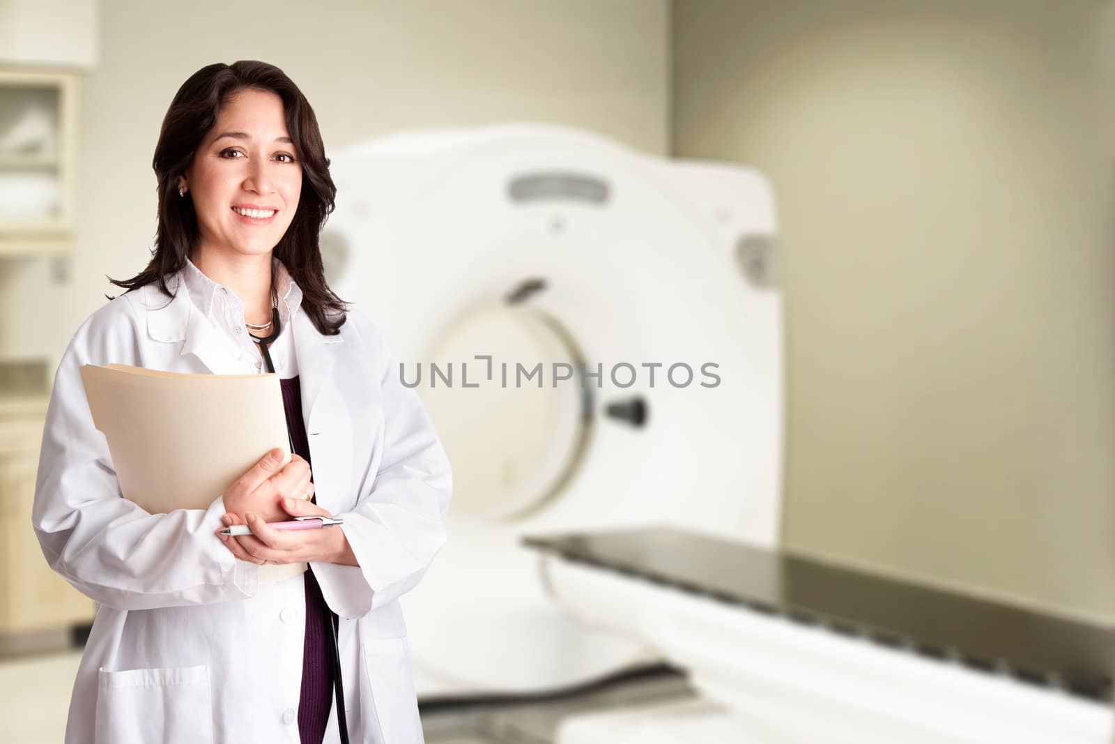 Beautiful happy female doctor physician radiologist holding patient medical chart and pen standing in CT CAT Scan room at hospital, isolated.