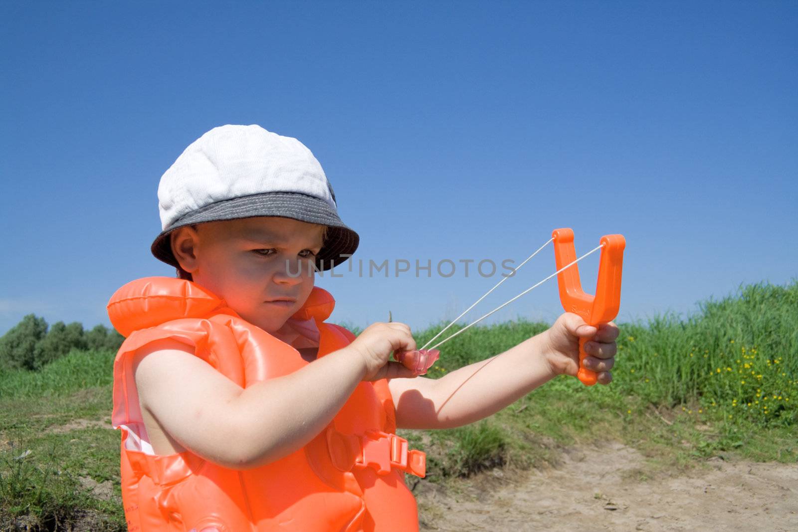 Boy holds an orange slingshot by Kriblikrabli