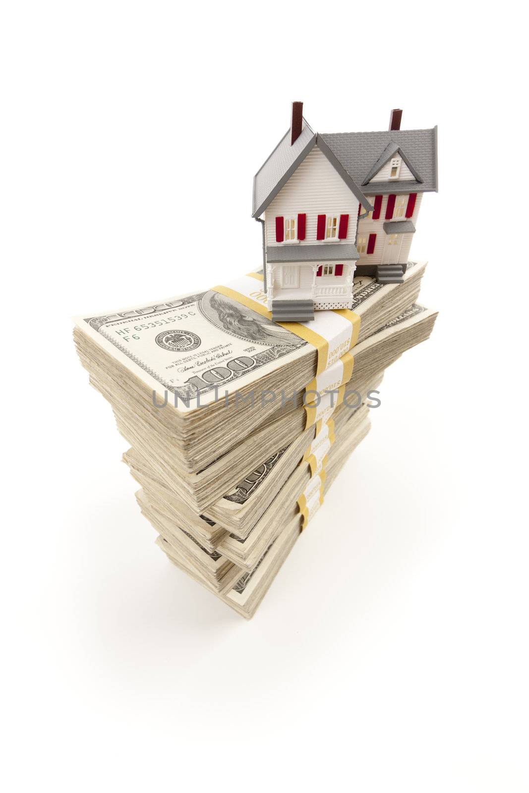 Small House on Stacks of Hundred Dollar Bills Isolated on a White Background.