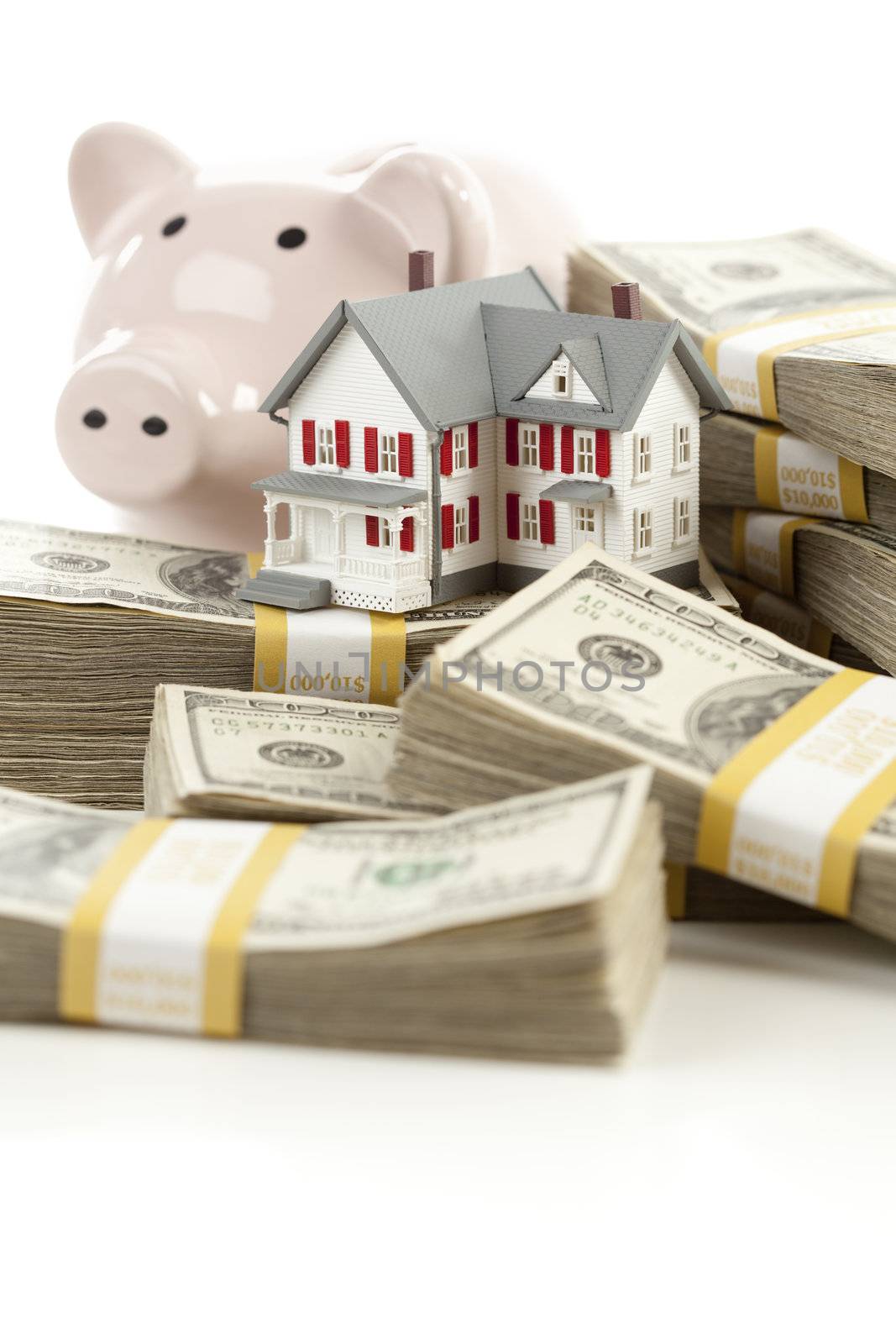 Small House and Piggy Bank with Stacks of Hundred Dollar Bills Isolated on a White Background.