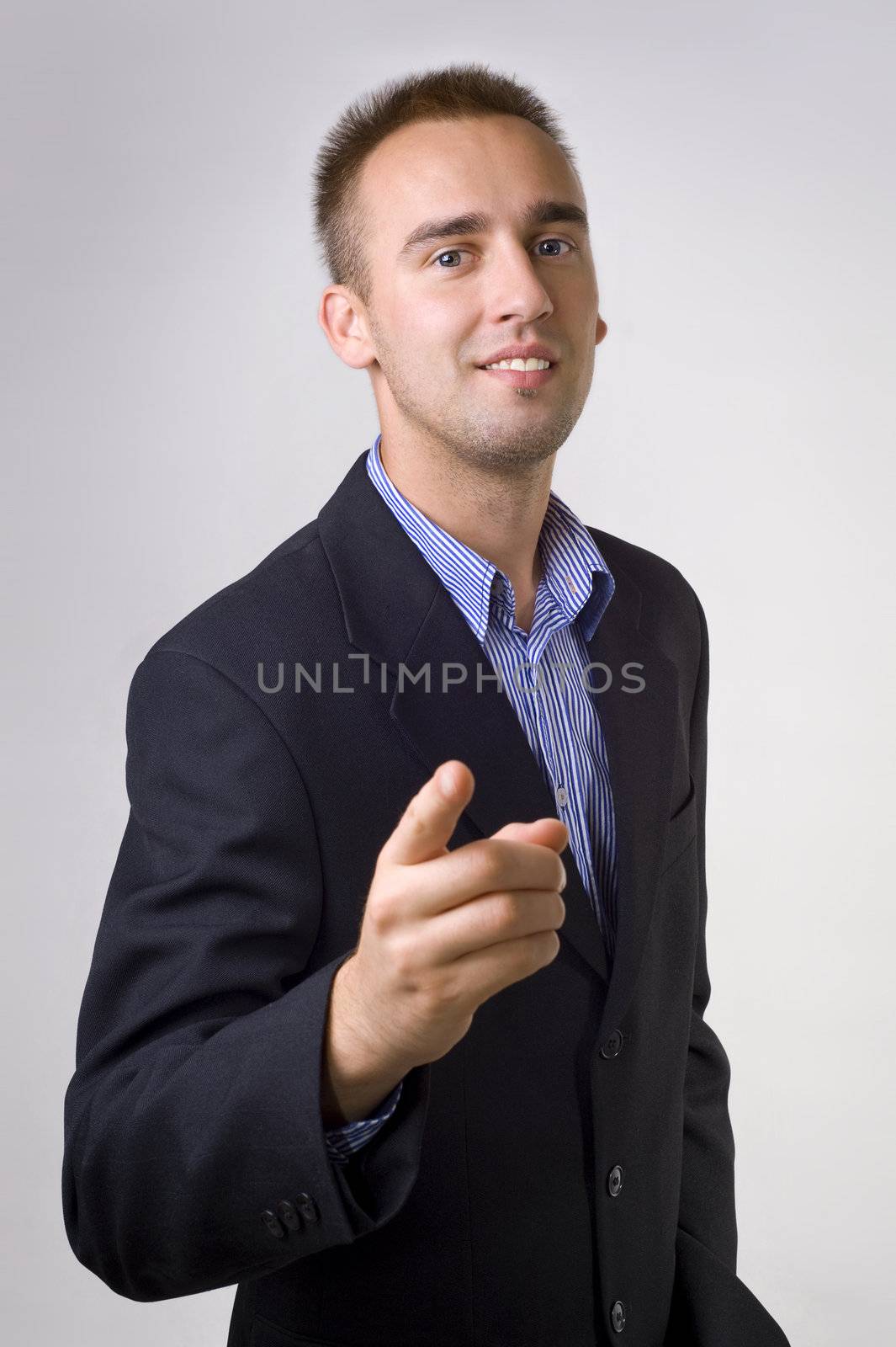 young male smiling bussinesman pointing his finger at you