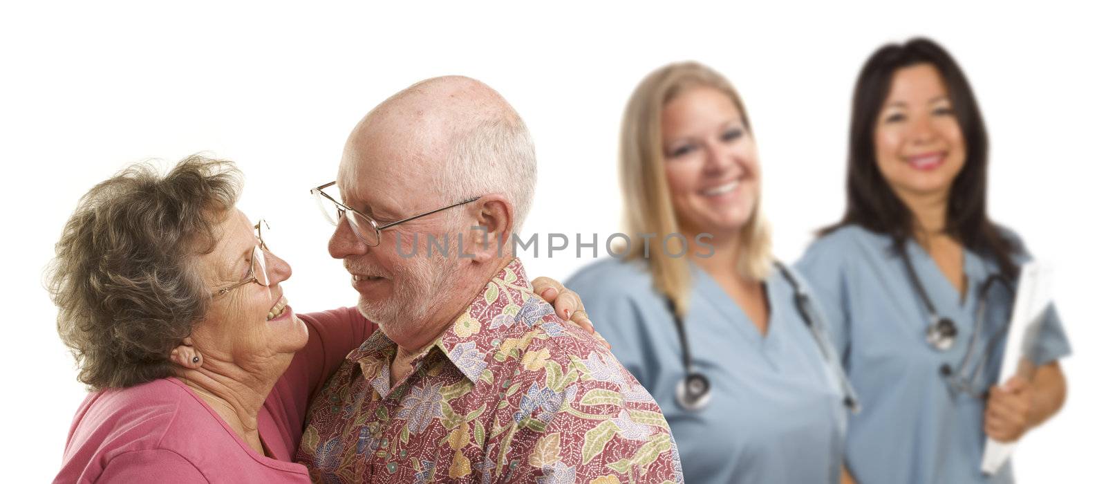 Happy Loving Senior Couple with Smiling Medical Doctors or Nurses Behind Isolated on a White Background.