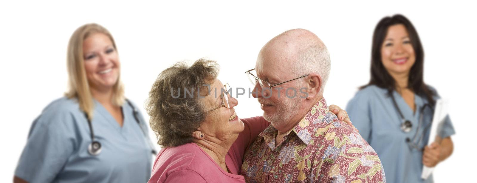 Happy Loving Senior Couple with Smiling Medical Doctors or Nurses Behind Isolated on a White Background.