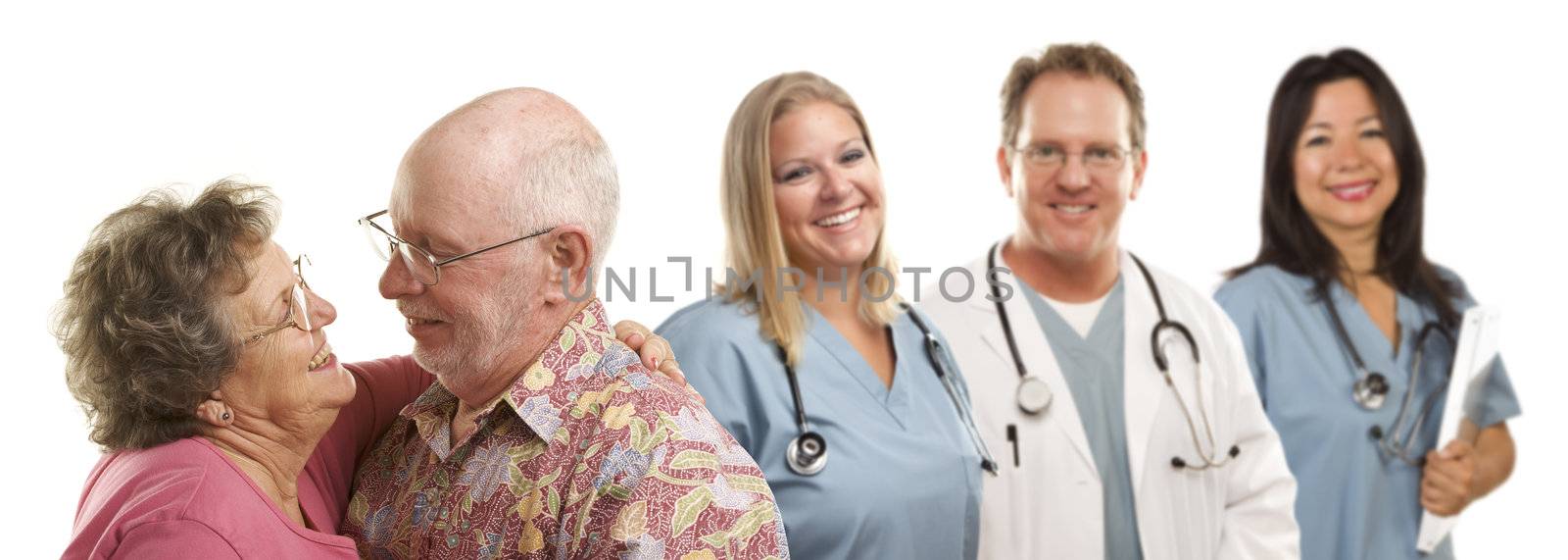 Happy Loving Senior Couple with Smiling Medical Doctors or Nurses Behind Isolated on a White Background.