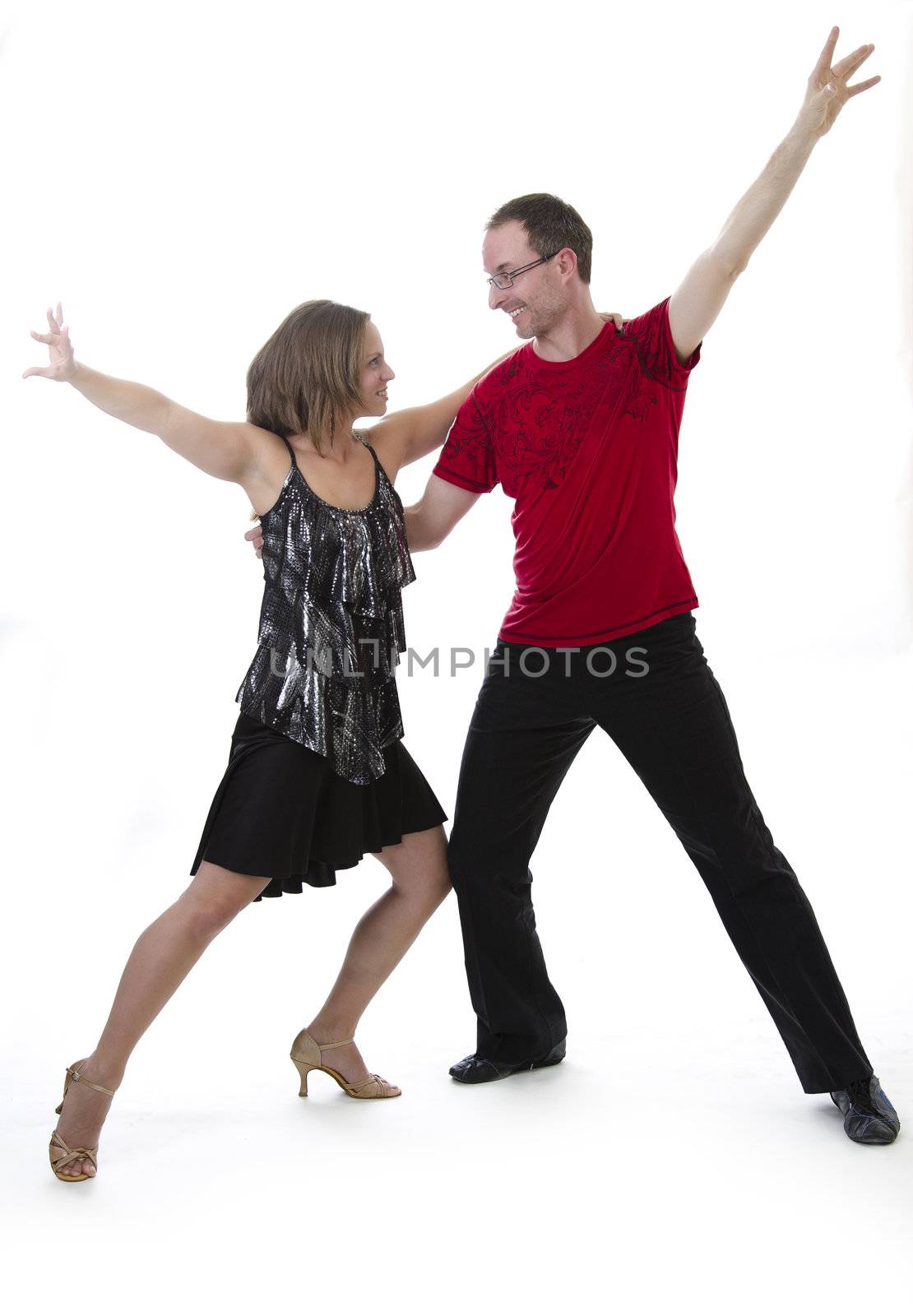 Man and woman dancing salsa looking into each other eyes against a white background