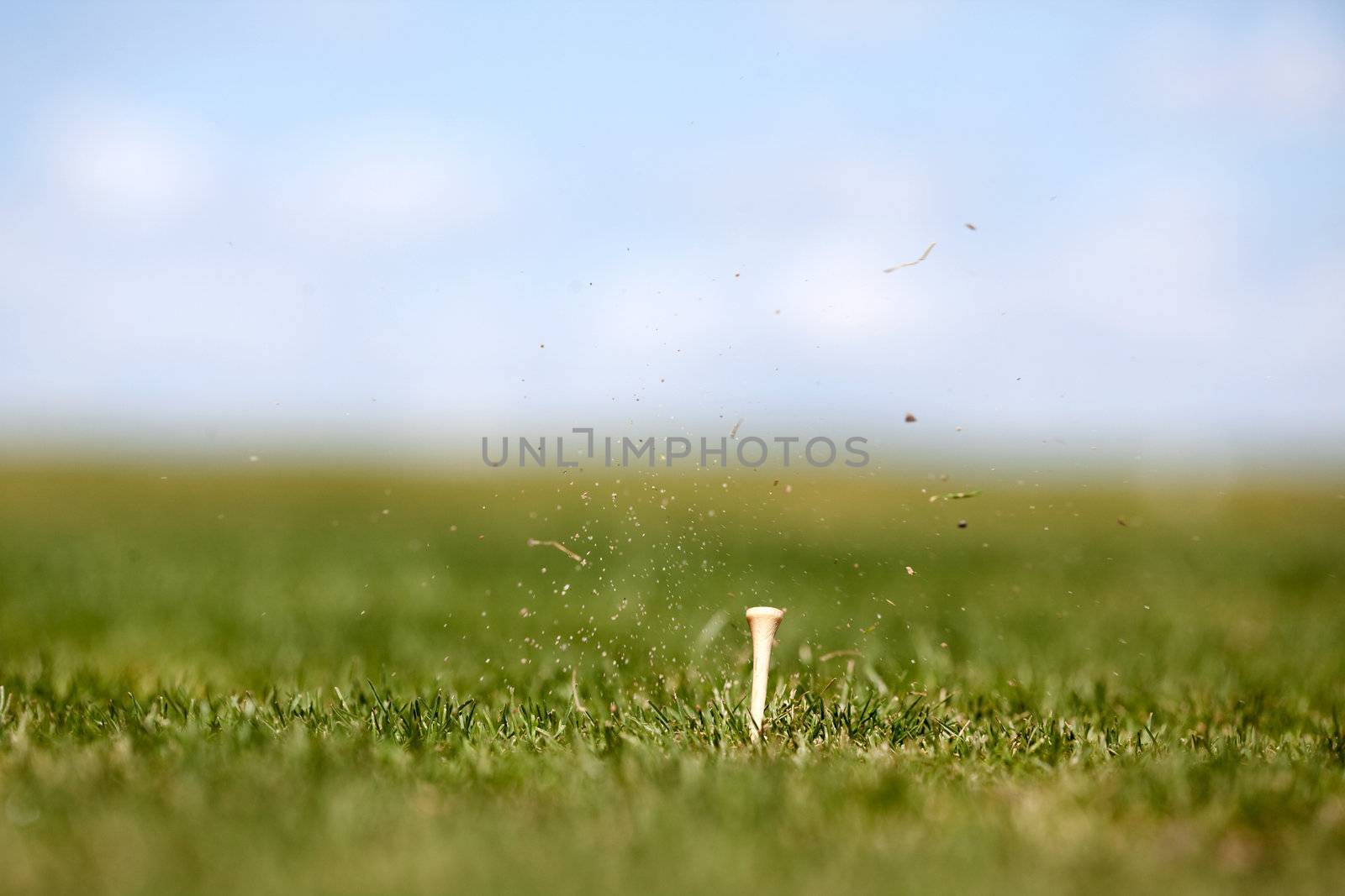 The after effects of a golf swing.  Shallow depth of field with focus on the tee