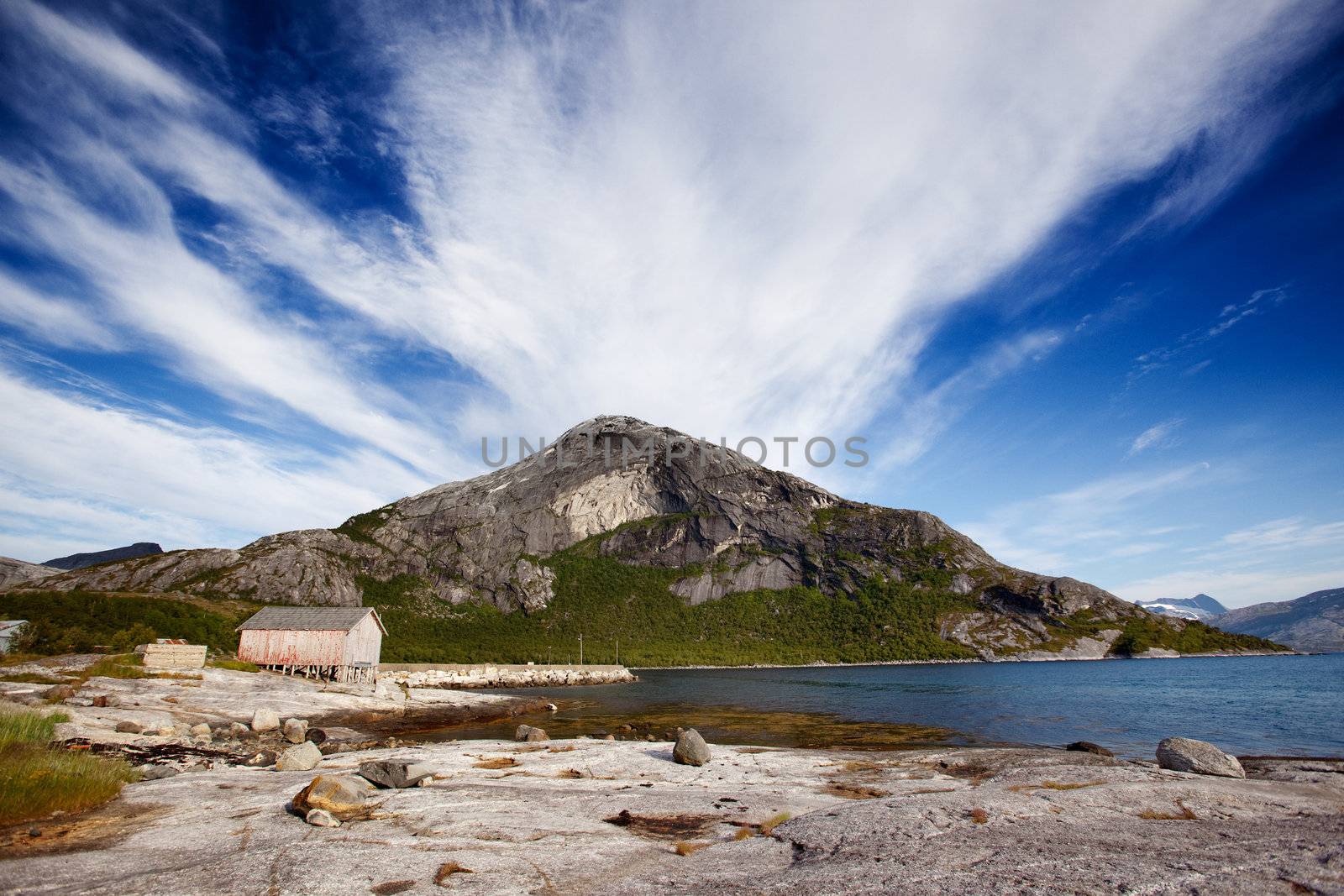A mountain on the coast of Norway near a small fishing village