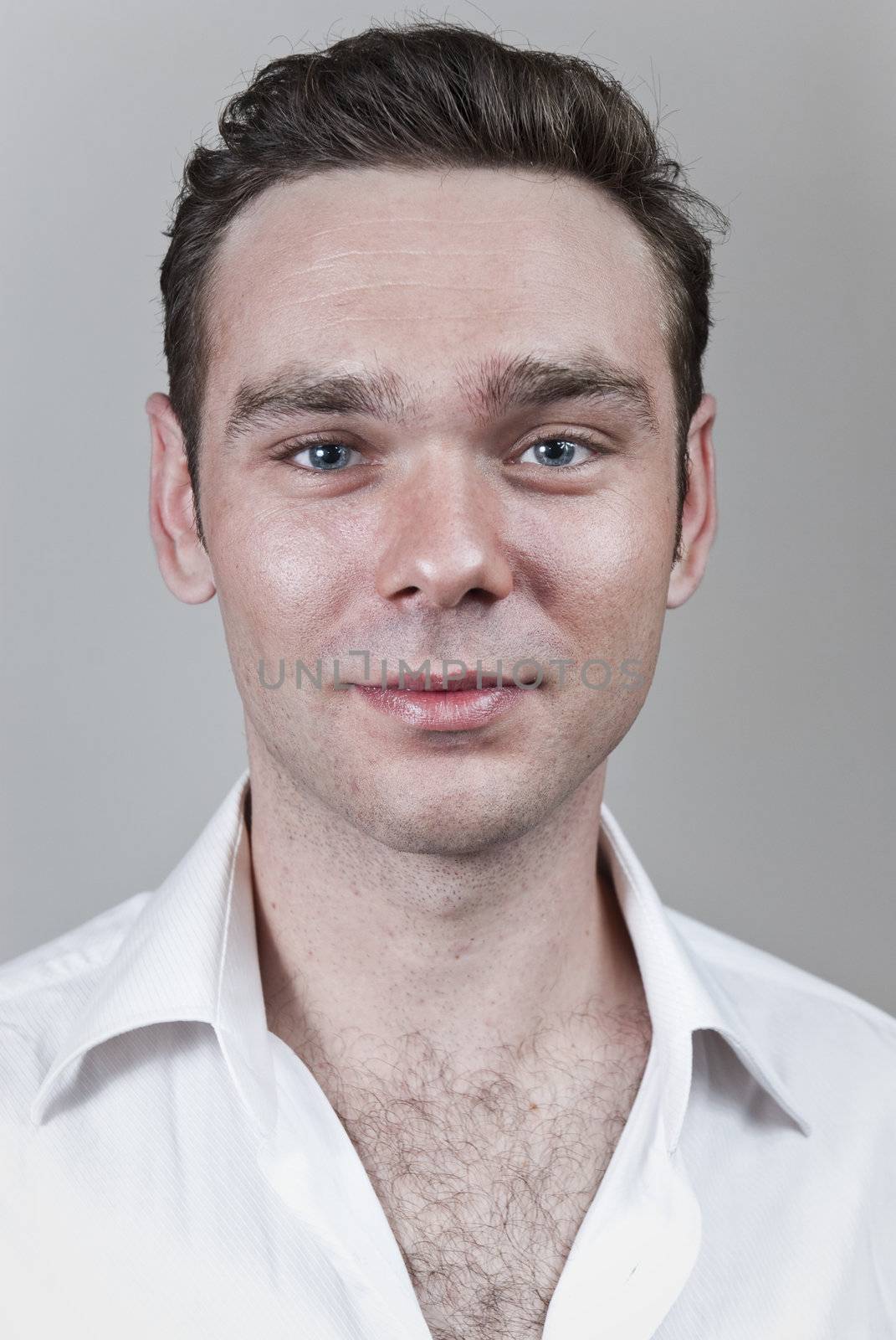 Headshot of young white man with neutral gray background.