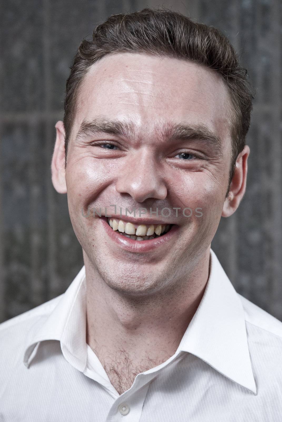 Headshot of young white man laughing and looking straight into the camera.