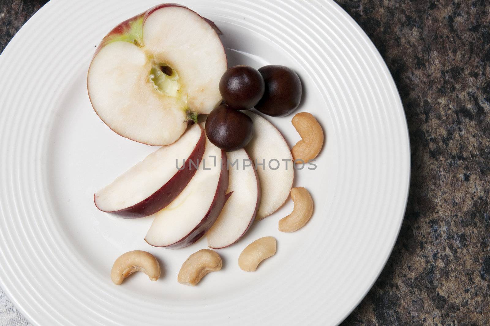 Arrangement of apples and nuts on a white plate