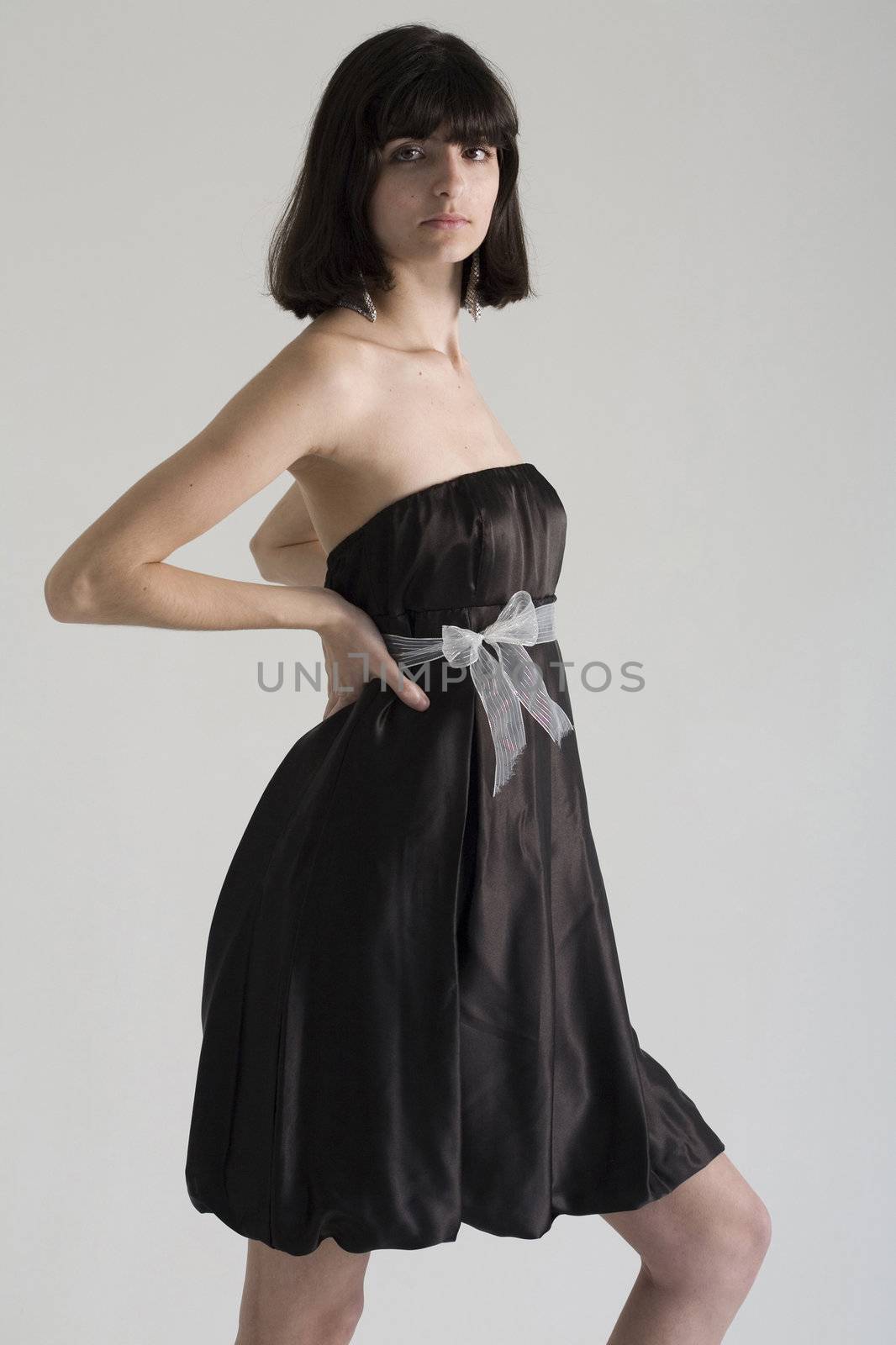 An 18 year old exotic brazilian model, with short dark hair, a young looking face and a skinny body. This was shot in a studio and she's weariing a black, strapless dress.