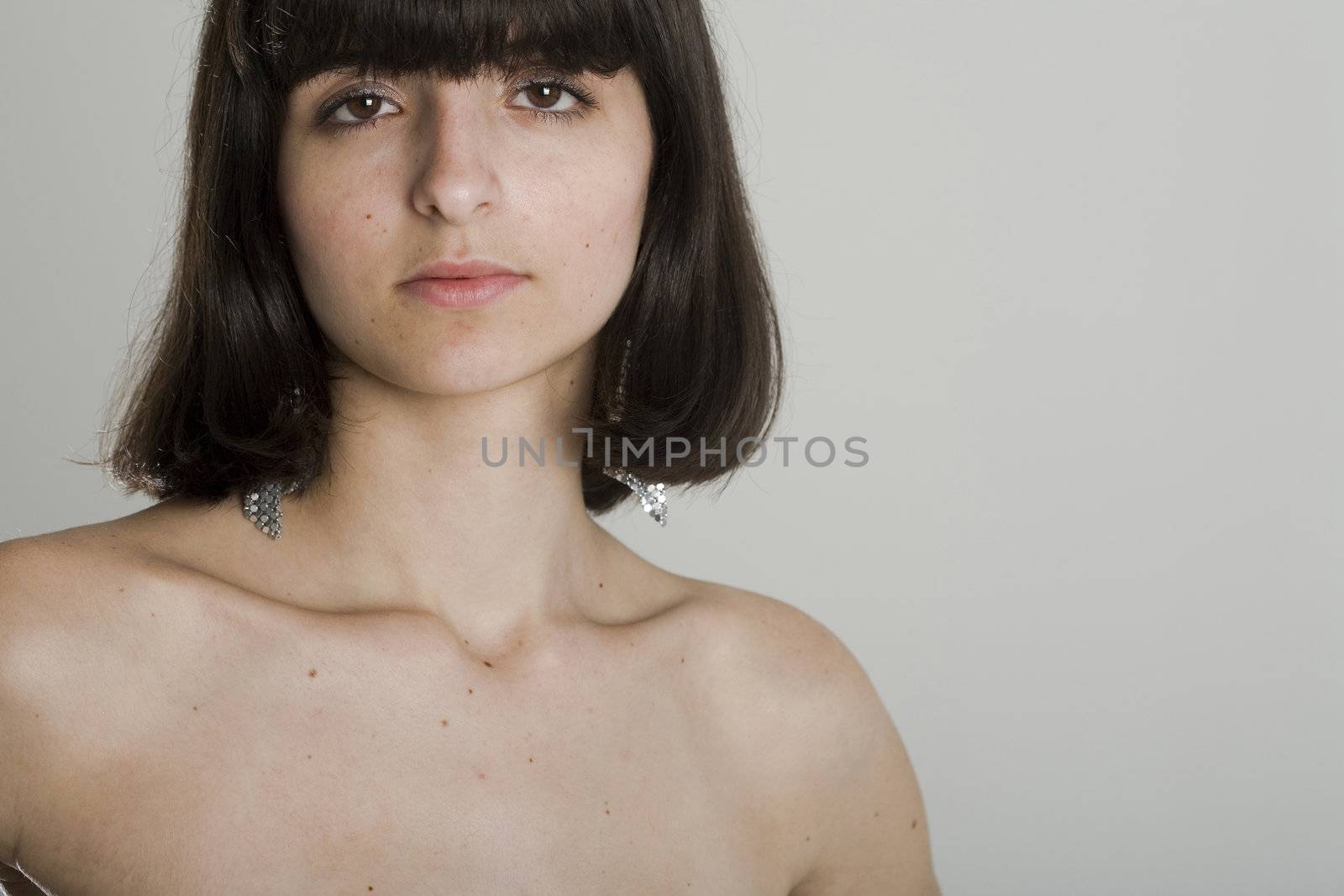 An 18 year old exotic brazilian model, with short dark hair, a young looking face and a skinny body. This was shot in a studio and she's weariing a black, strapless dress. Plenty of copyspace in the image.