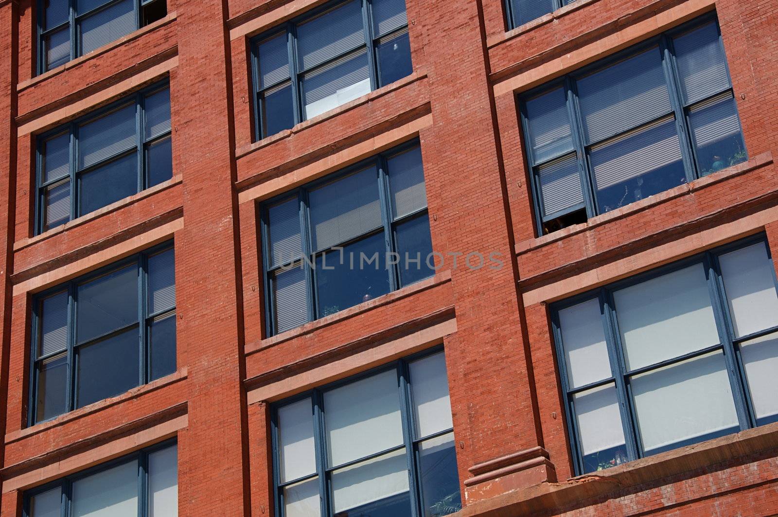 The exterior of a building in Denver, Colorado is red brick with blue painted windows.