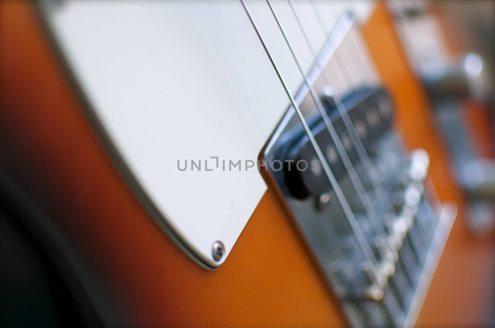 An electric guitar shines in the light of a nearby window.  Shallow depth of field is intentional.