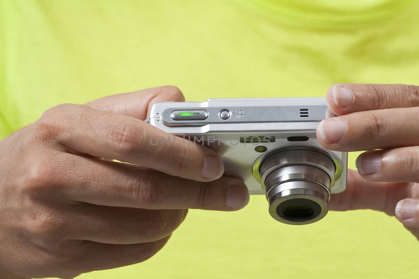 Closeup on hands holding a digital camera while reviewing pictures