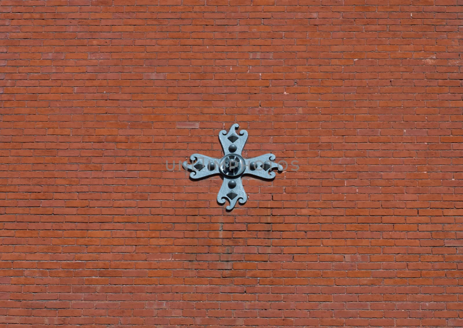 Brick wall with steel cross by bobkeenan