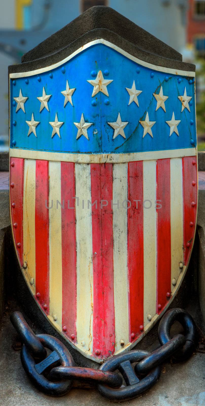 An HDR image of a metal american flag emblem at the base of a memorial