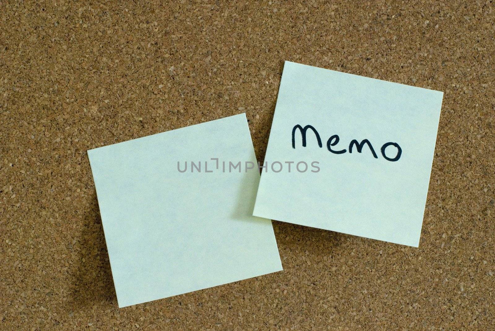 two sticky notes on a cork notice board