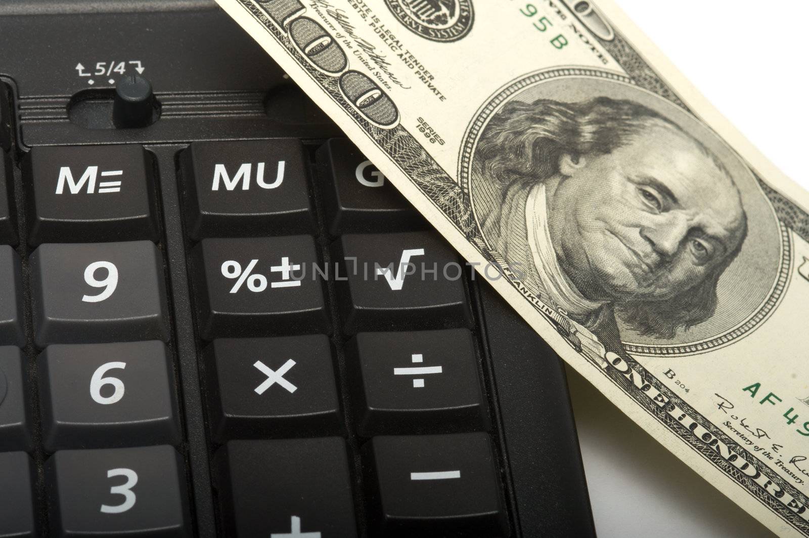 Banknote hundred dollars and the calculator, a close up.