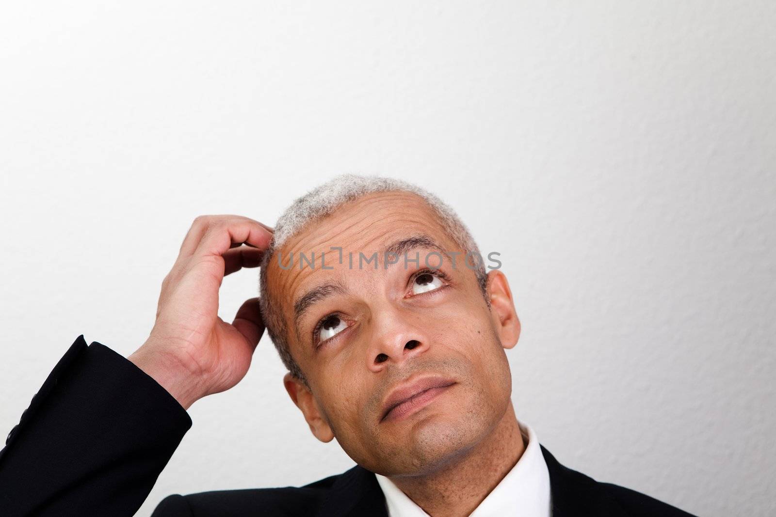 Portrait of thinking businessman looking up into copyspace